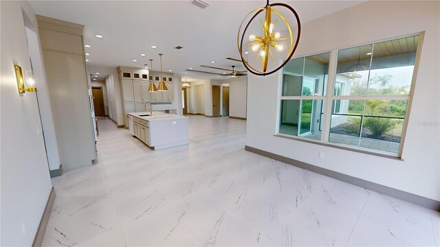 kitchen with pendant lighting, light tile flooring, a center island with sink, sink, and an inviting chandelier