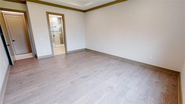 unfurnished bedroom featuring connected bathroom and light wood-type flooring