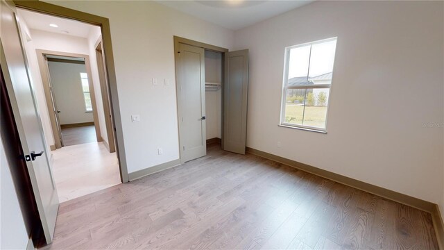 unfurnished bedroom featuring a closet and light wood-type flooring