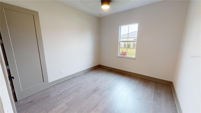 empty room with ceiling fan and light hardwood / wood-style flooring