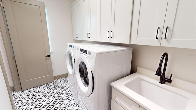 clothes washing area with cabinets, independent washer and dryer, sink, and light tile floors