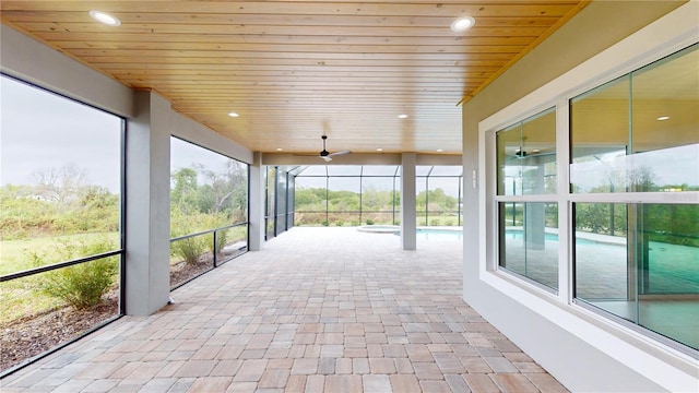 unfurnished sunroom featuring ceiling fan and wood ceiling