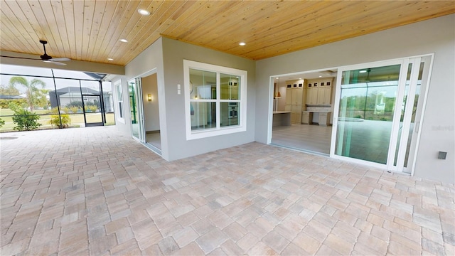 view of patio with exterior kitchen, ceiling fan, and a lanai