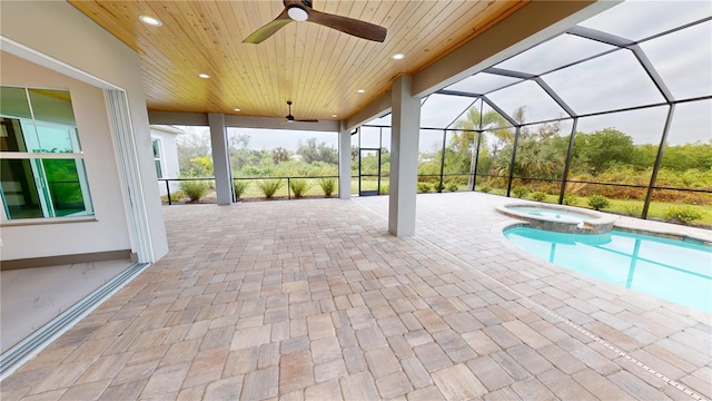 view of pool with a patio, an in ground hot tub, ceiling fan, and glass enclosure