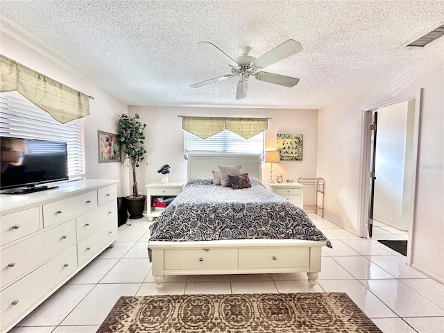 tiled bedroom with a textured ceiling and ceiling fan