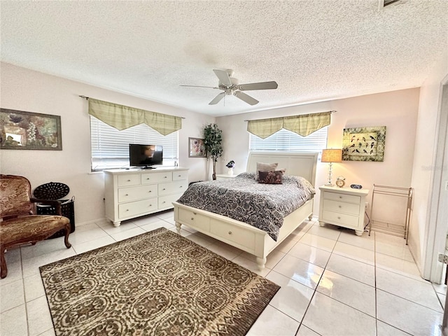 bedroom featuring a textured ceiling, ceiling fan, and light tile patterned floors