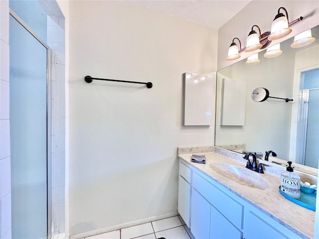 bathroom with a shower with door, vanity, and tile patterned floors