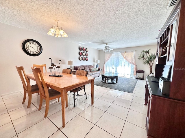 dining space featuring a textured ceiling, light tile patterned floors, and ceiling fan with notable chandelier