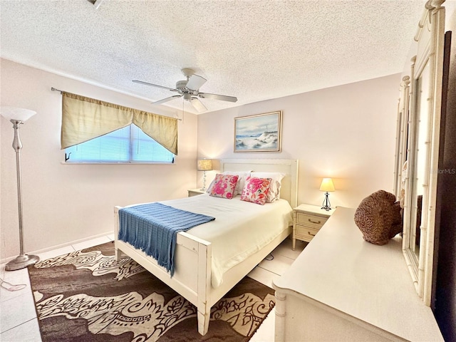 tiled bedroom featuring a textured ceiling and ceiling fan