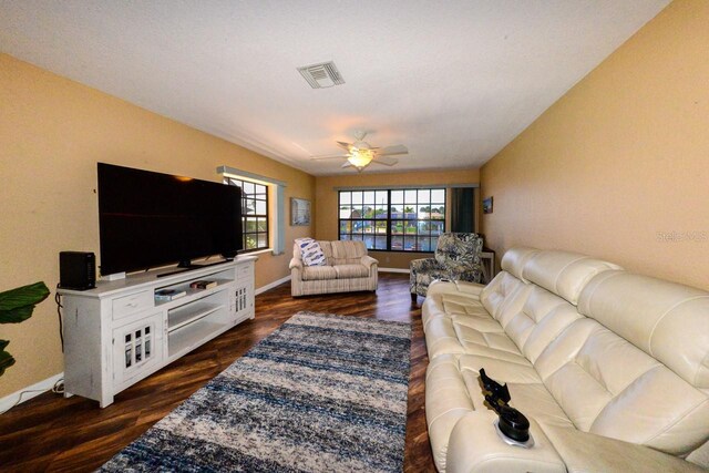 living room featuring dark hardwood / wood-style floors and ceiling fan