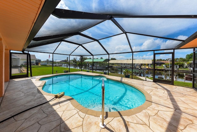 view of swimming pool featuring a water view, a lanai, a yard, and a patio area