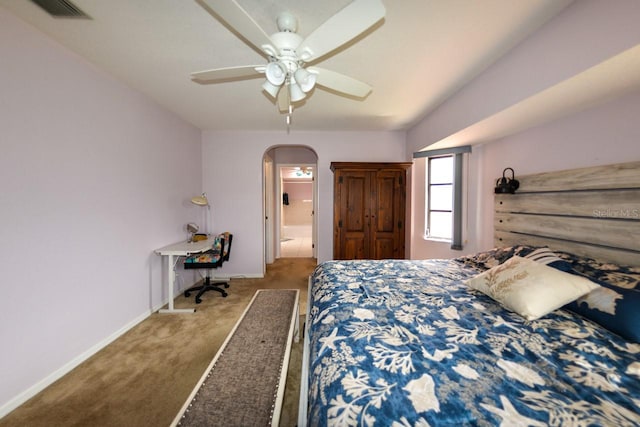 carpeted bedroom featuring ensuite bath and ceiling fan