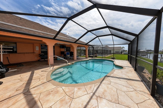 view of swimming pool with a lawn, a patio area, and glass enclosure