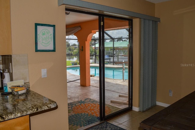 doorway featuring light tile flooring and a wealth of natural light