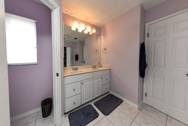 bathroom featuring large vanity, dual sinks, tile floors, and a wealth of natural light