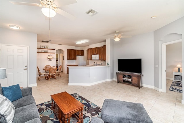 tiled living room featuring ceiling fan and sink