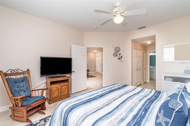 tiled bedroom with ensuite bathroom, a closet, and ceiling fan