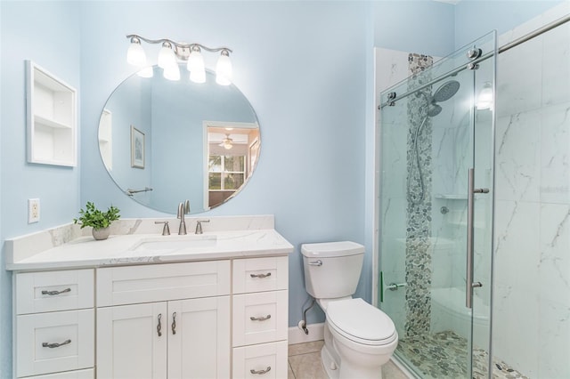 bathroom featuring ceiling fan, toilet, a shower with door, and vanity