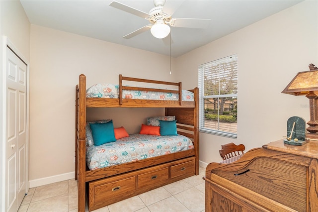 bedroom with ceiling fan, a closet, and light tile patterned flooring