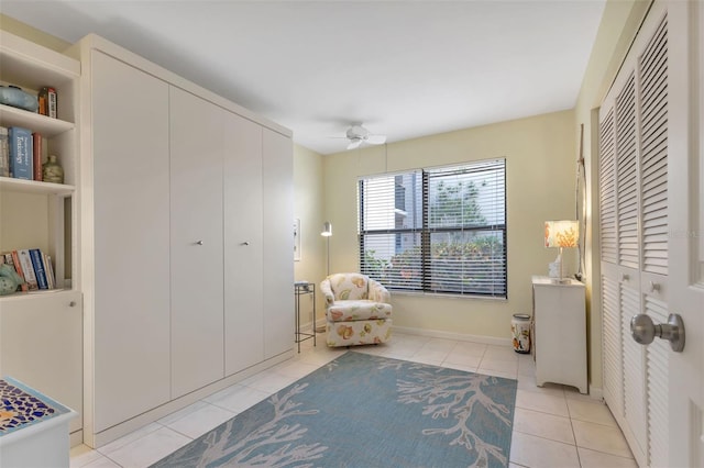 living area featuring light tile flooring and ceiling fan