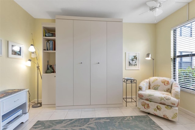 sitting room featuring light tile floors and ceiling fan