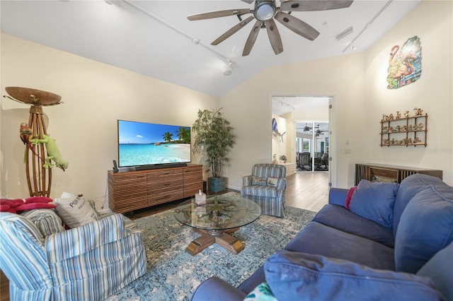 living room with lofted ceiling, rail lighting, ceiling fan, and hardwood / wood-style flooring