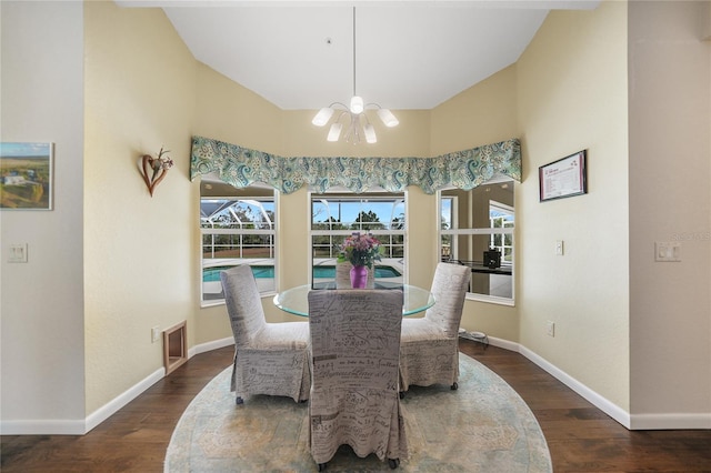 dining space featuring an inviting chandelier, lofted ceiling, and dark hardwood / wood-style floors