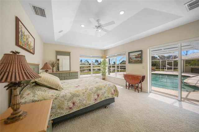 bedroom with access to exterior, a raised ceiling, carpet flooring, and ceiling fan