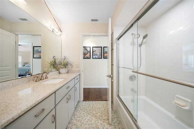 bathroom with oversized vanity, tile floors, bath / shower combo with glass door, and ceiling fan