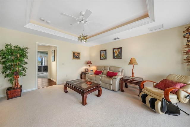 living room featuring ceiling fan, light carpet, and a raised ceiling