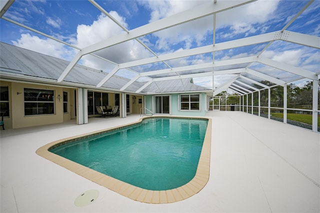 view of swimming pool with glass enclosure and a patio area