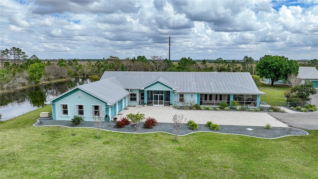 ranch-style home featuring a water view and a front lawn