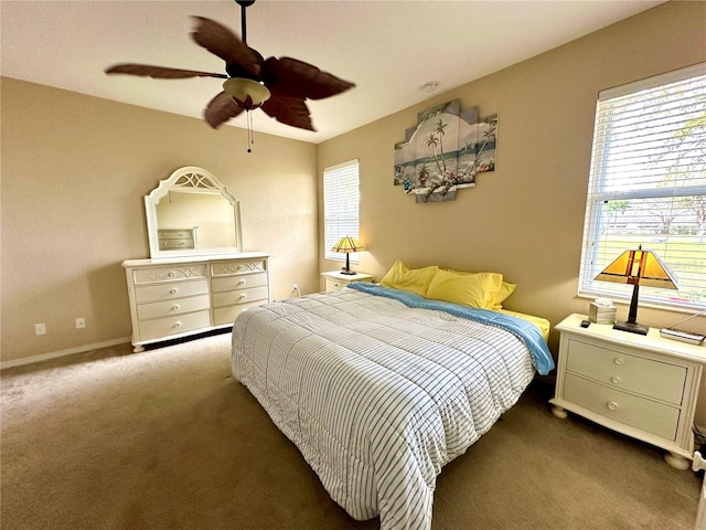 carpeted bedroom with multiple windows and ceiling fan