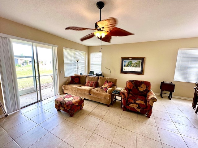 tiled living room featuring ceiling fan, a healthy amount of sunlight, and a textured ceiling