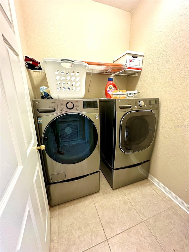 laundry room with light tile patterned floors and washing machine and clothes dryer