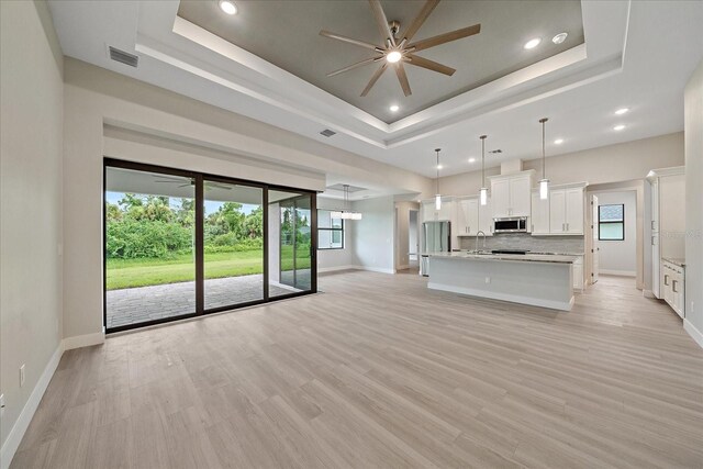 kitchen with white cabinets, a tray ceiling, and decorative backsplash