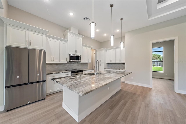 kitchen with light wood-type flooring, backsplash, stainless steel appliances, sink, and white cabinets