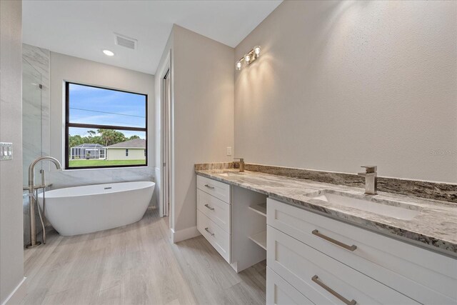 bathroom with a tub and vanity