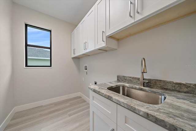 interior space with cabinets, light hardwood / wood-style floors, sink, hookup for an electric dryer, and washer hookup