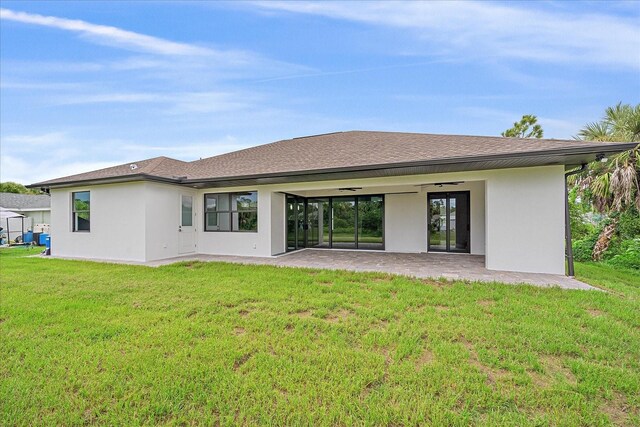 rear view of property with a patio area, a yard, and ceiling fan