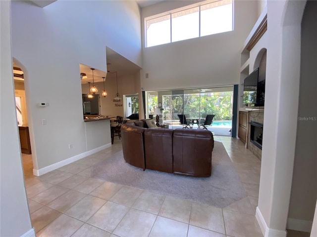 tiled living room with a high ceiling and a healthy amount of sunlight