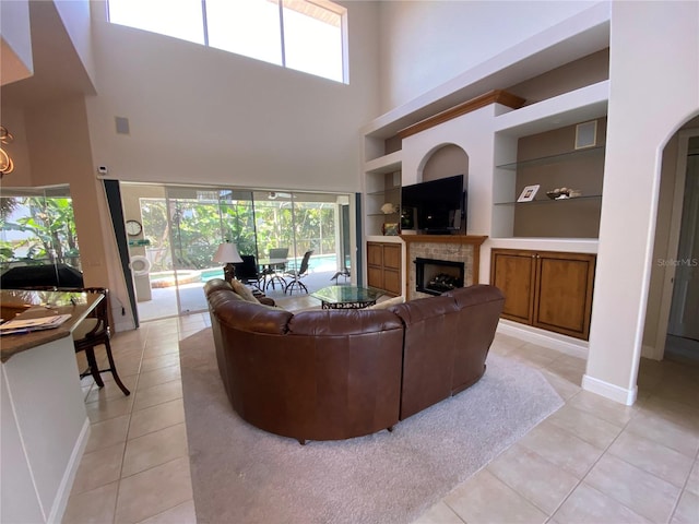 tiled living room with a high ceiling and built in features