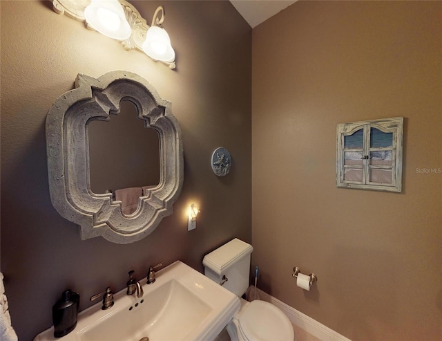 bathroom with vaulted ceiling, toilet, and sink