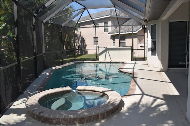 view of swimming pool featuring an in ground hot tub, a lanai, and a patio area