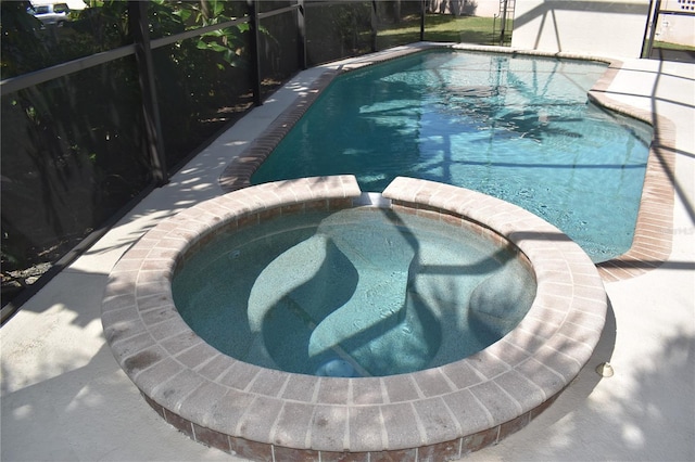 view of swimming pool featuring an in ground hot tub