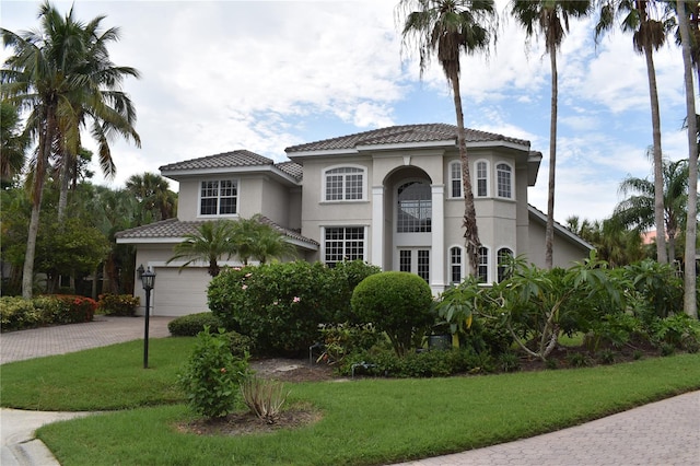 mediterranean / spanish-style house with a front lawn and a garage