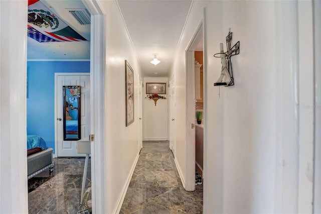 hallway with dark tile floors and ornamental molding