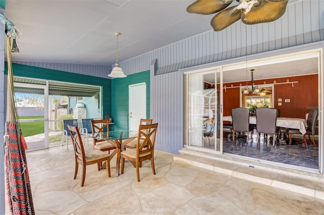 dining area with light tile floors, ceiling fan with notable chandelier, and vaulted ceiling