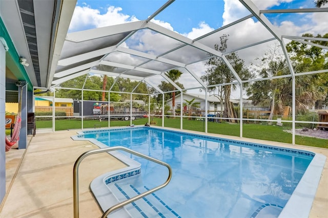 view of pool with a lawn, a patio area, and a lanai