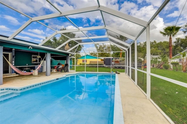 view of pool with a lanai, a lawn, and a patio